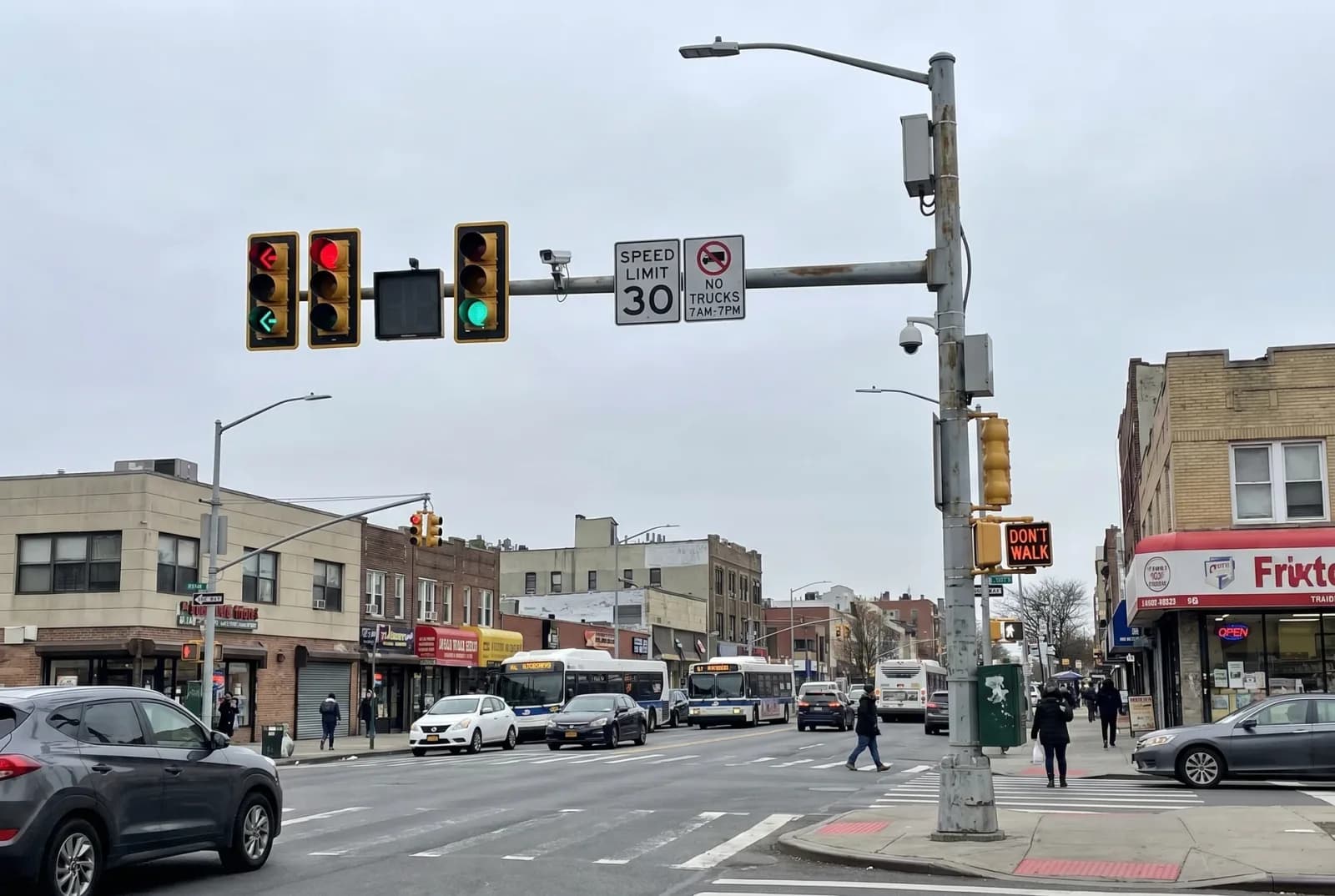 BF-SMP-T Series cantilever arm traffic pole at a wide intersection — multi-signal span with speed limit and surveillance equipment