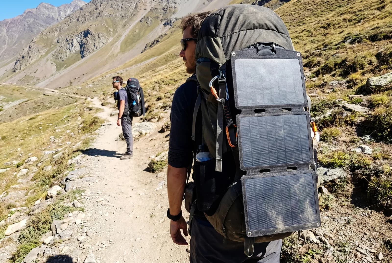 BF-PV-F series foldable solar panel strapped to a hiker's backpack on a mountain trail
