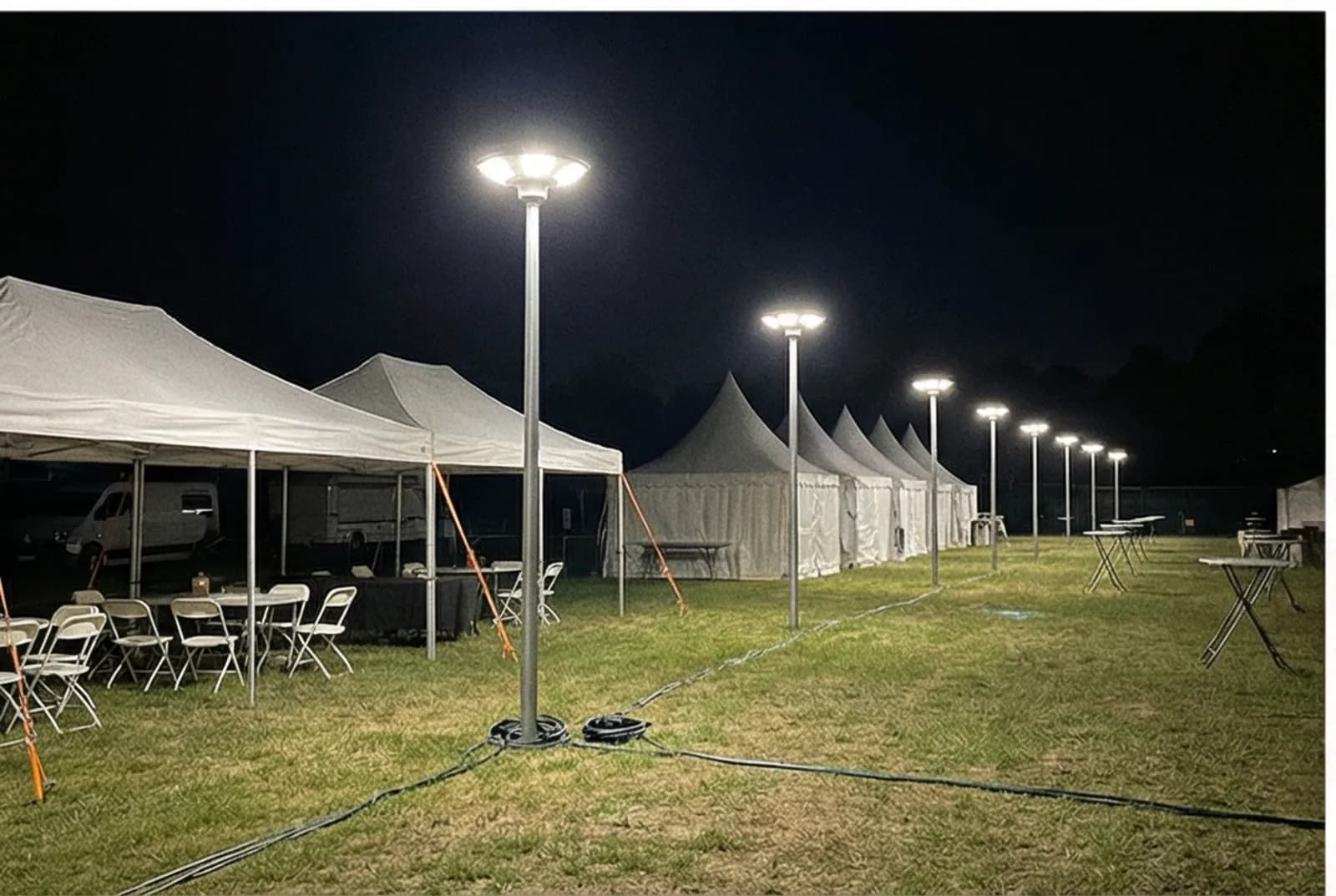 Solar landscape lights illuminating an outdoor event venue with tents at night