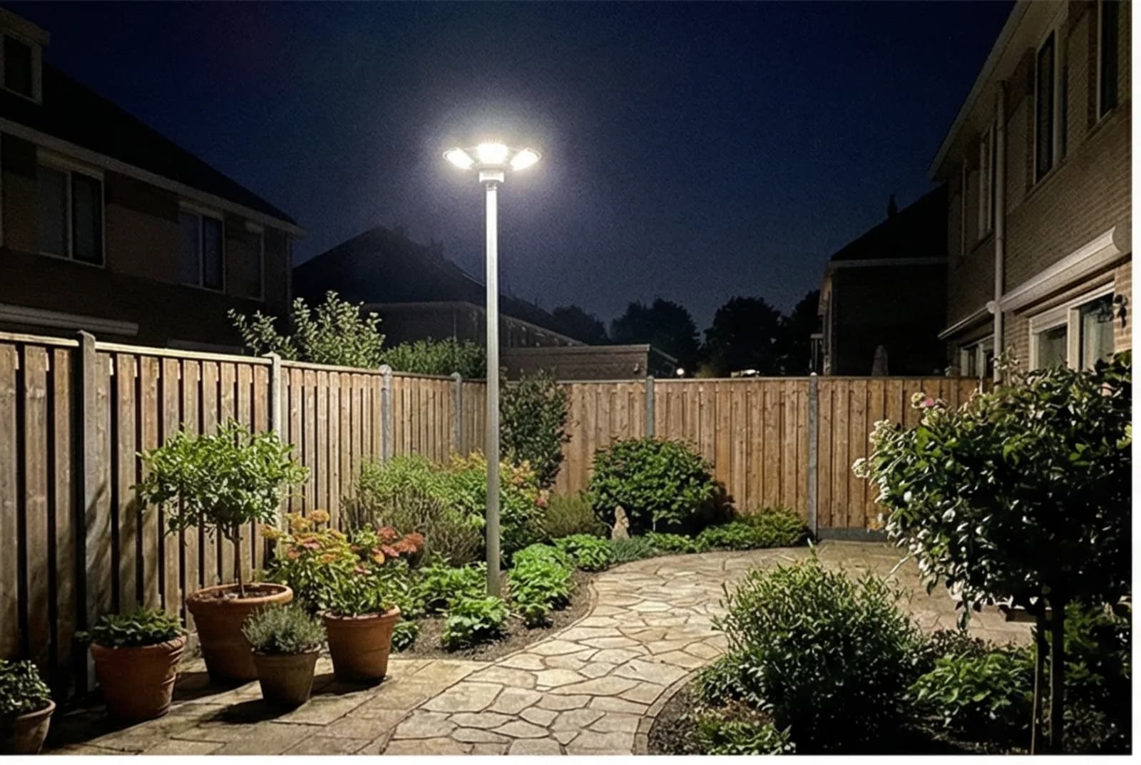 Solar landscape lights illuminating a residential garden and backyard pathway at night